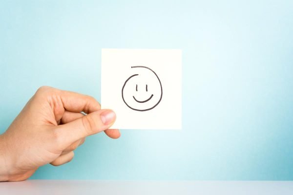 Happy employee. Happy emoticon or icon on blue background.